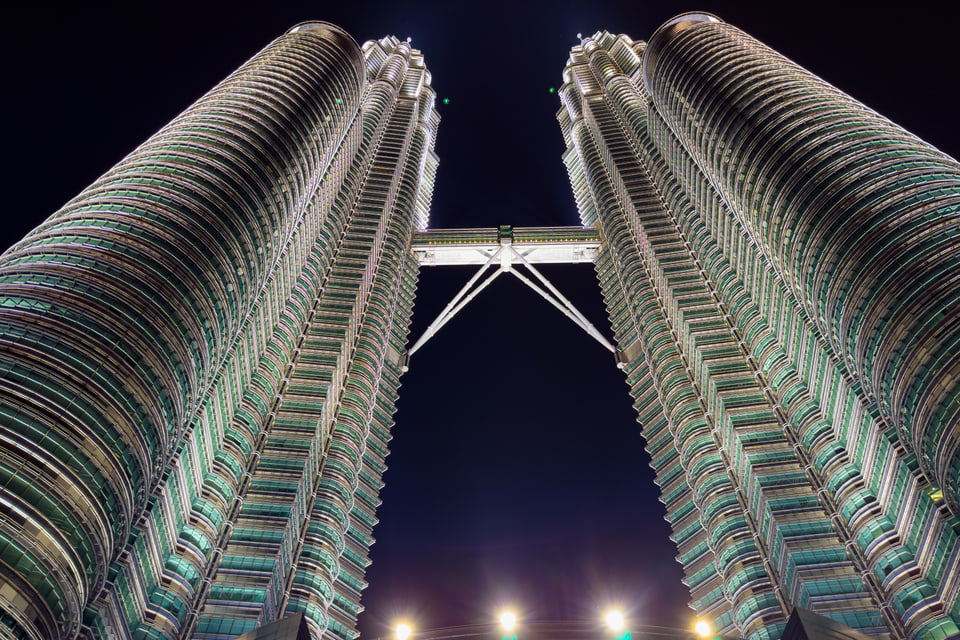 Petronas Twin Towers illuminated at night from below.